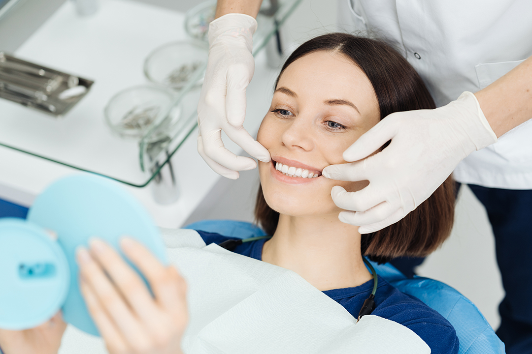 A woman receiving dental care from a professional in a clinical setting.