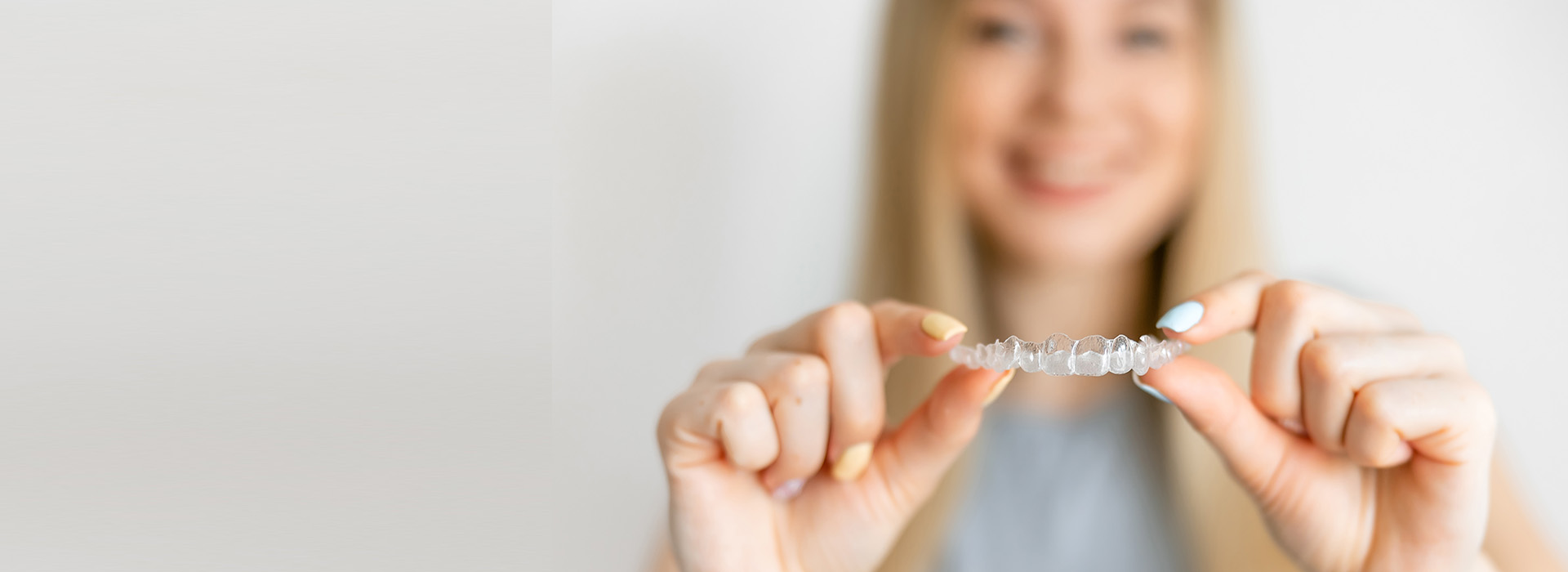 Woman holding a ring in her hand with a blurred background.