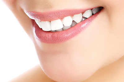 The image features a close-up of a person s face with a focus on their teeth, which are being showcased for a dental product advertisement.