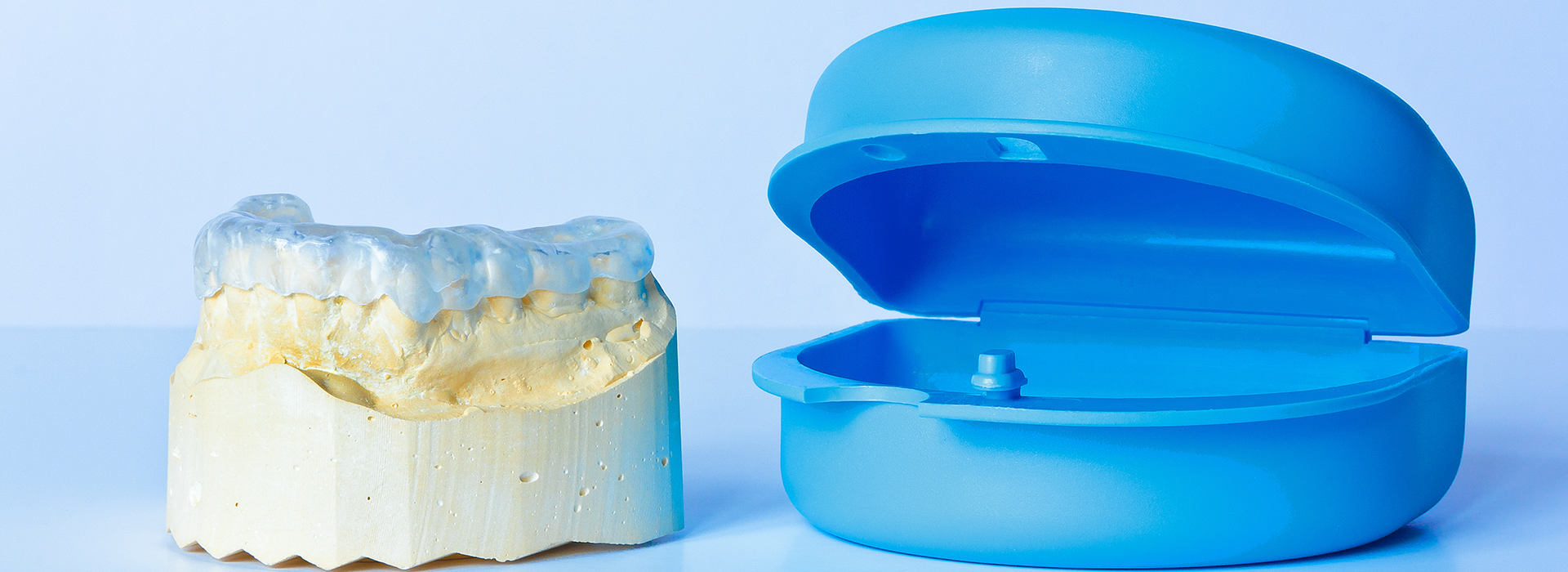 An image featuring dental models and a blue object, possibly for educational or demonstration purposes.